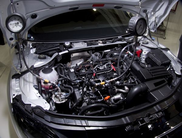 vehicle diagnostics for European vehicles in Denver, CO. Image of luxury car engine on car with raised hood in shop.